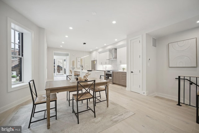 dining room featuring a healthy amount of sunlight, light wood finished floors, baseboards, and recessed lighting