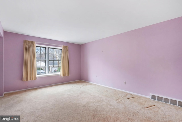 unfurnished room featuring carpet, visible vents, and baseboards