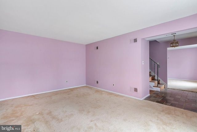 carpeted empty room featuring stairway, visible vents, and a chandelier