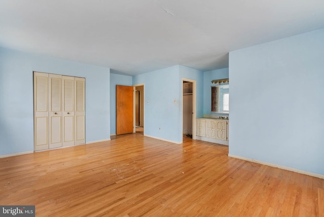 unfurnished bedroom with light wood-style floors, a closet, and baseboards