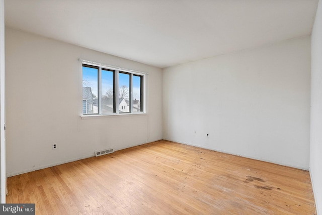 empty room featuring visible vents and wood finished floors