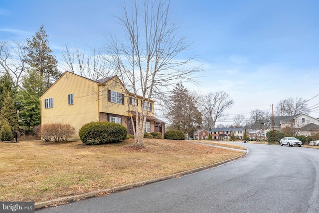 view of property exterior with a yard and brick siding