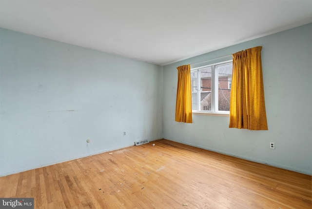 spare room with light wood finished floors and visible vents