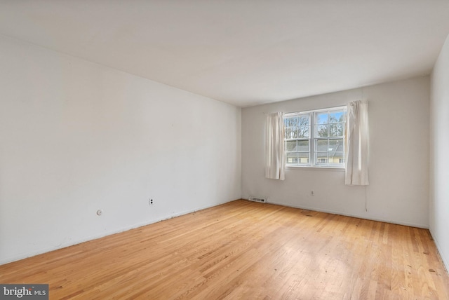 unfurnished room featuring light wood finished floors and visible vents