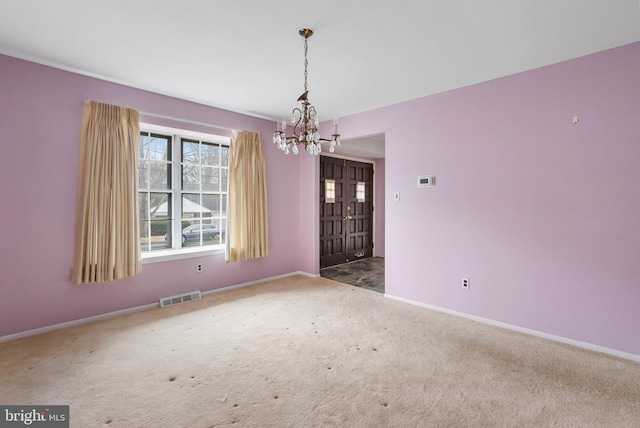 empty room with carpet, visible vents, baseboards, and an inviting chandelier