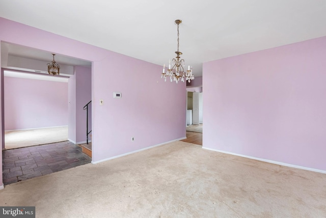 spare room with a chandelier, carpet, stairs, and baseboards