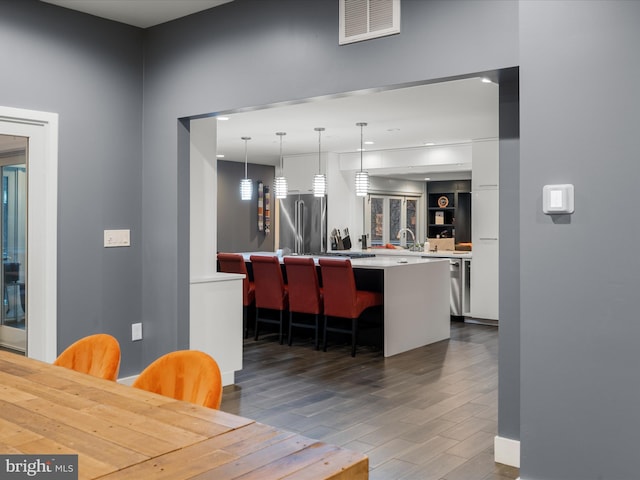 dining area with visible vents and wood finished floors