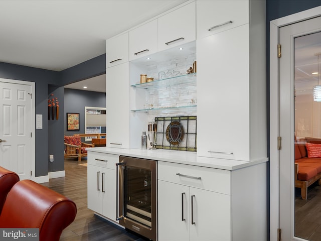 bar featuring beverage cooler, dark wood-style floors, a dry bar, and baseboards