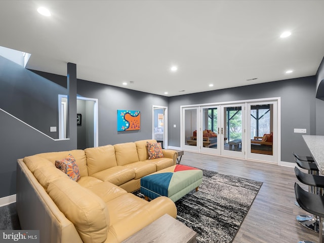 living room with wood finished floors, recessed lighting, baseboards, and french doors