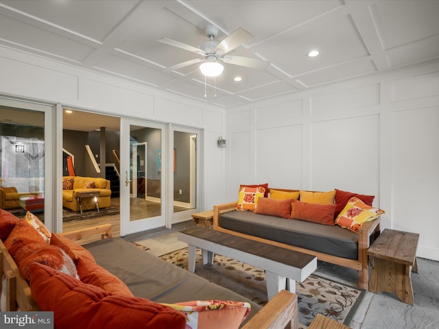 living room featuring beam ceiling, a ceiling fan, coffered ceiling, recessed lighting, and a decorative wall