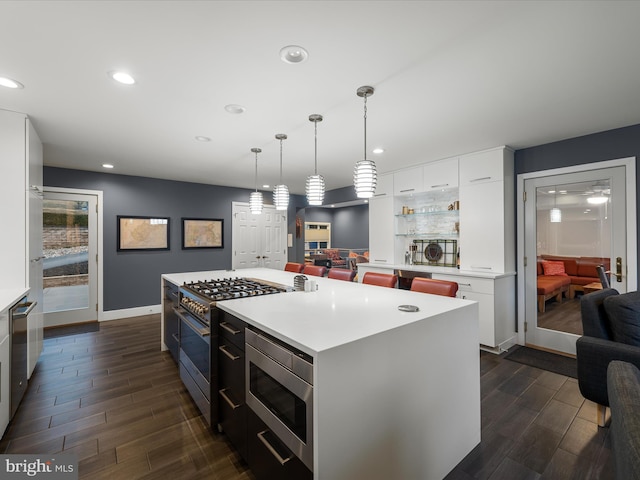 kitchen with wood finish floors, appliances with stainless steel finishes, recessed lighting, and white cabinetry