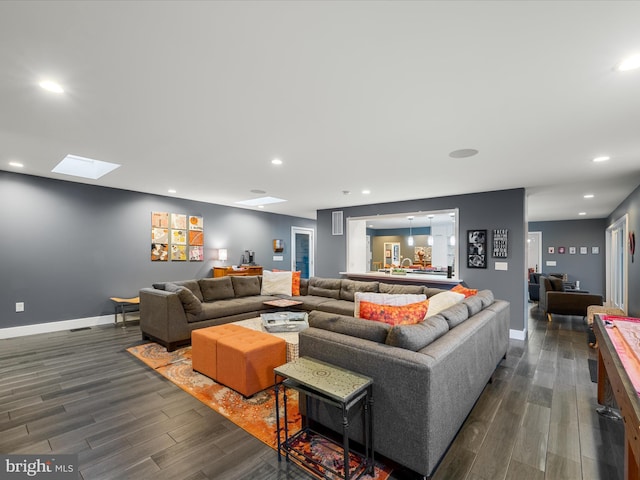 living area with recessed lighting, baseboards, dark wood-style floors, and a skylight