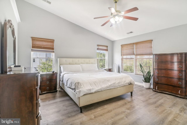 bedroom featuring vaulted ceiling, visible vents, light wood-style flooring, and baseboards