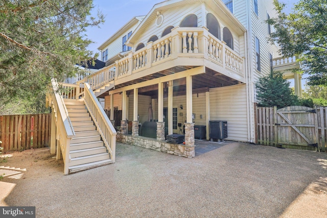 rear view of house featuring a patio, cooling unit, fence, stairs, and a gate