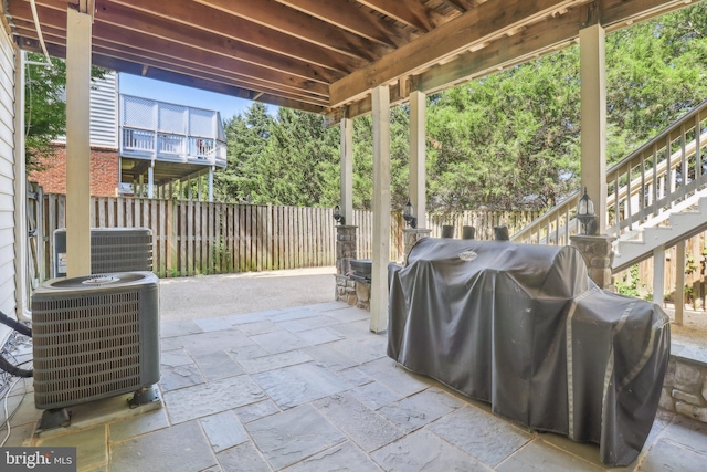 view of patio with grilling area, fence, and central air condition unit