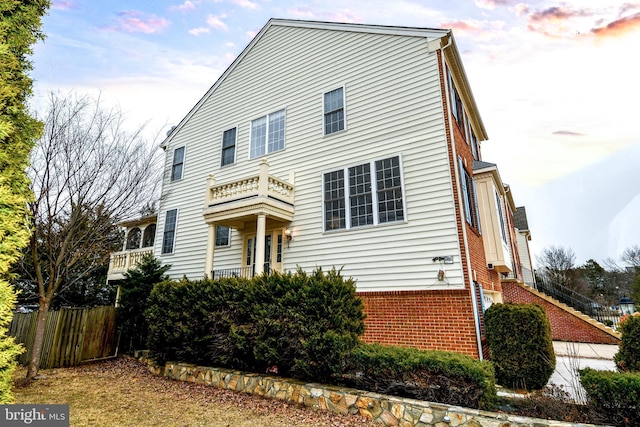 view of front of property featuring fence and brick siding