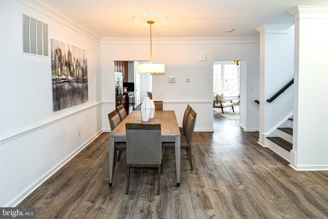 dining room featuring dark wood finished floors, visible vents, crown molding, and stairway