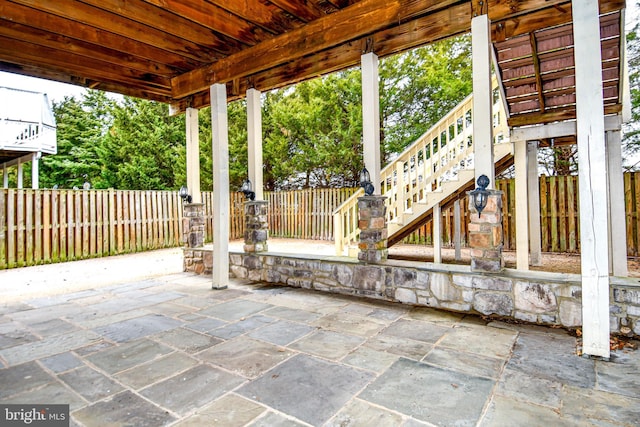 view of patio / terrace featuring stairs and fence