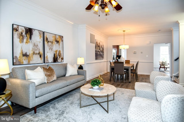 living area featuring crown molding, baseboards, and wood finished floors