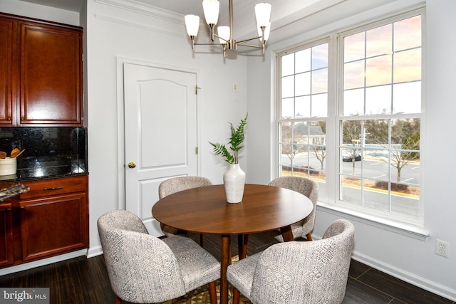 dining area with baseboards, dark wood finished floors, and an inviting chandelier