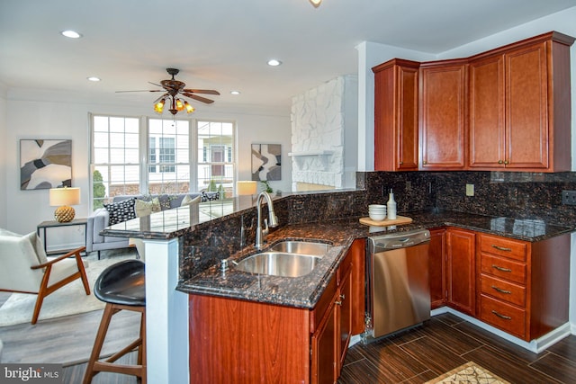 kitchen featuring a peninsula, a sink, open floor plan, stainless steel dishwasher, and decorative backsplash