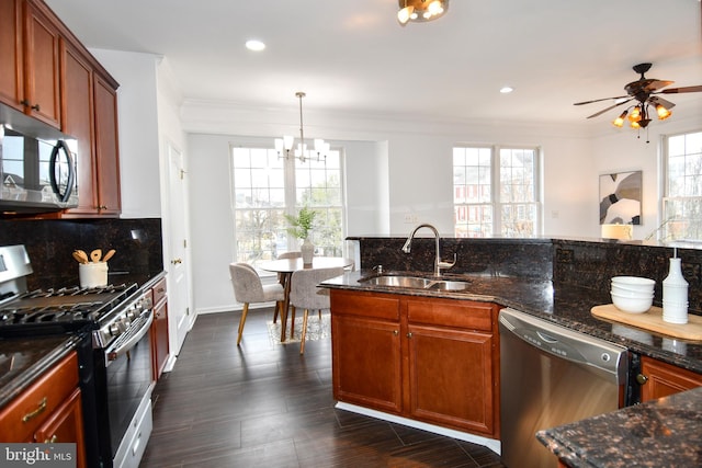 kitchen featuring stainless steel appliances, dark wood-type flooring, a sink, backsplash, and crown molding