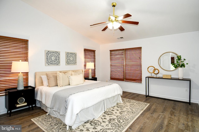 bedroom featuring visible vents, baseboards, ceiling fan, dark wood-style flooring, and vaulted ceiling