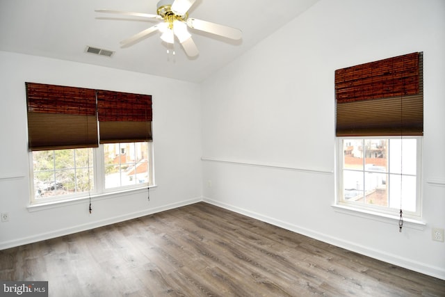 spare room with baseboards, visible vents, ceiling fan, and wood finished floors