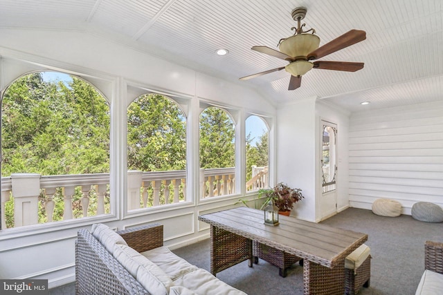 sunroom / solarium with lofted ceiling and a ceiling fan