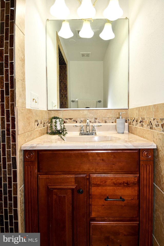 bathroom featuring visible vents, tile walls, and vanity