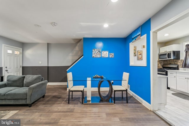 sitting room with baseboards, wood finished floors, and recessed lighting