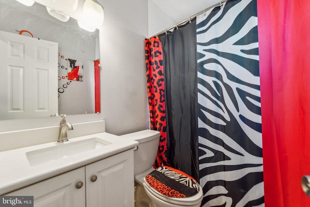 bathroom featuring toilet, a shower with shower curtain, and vanity