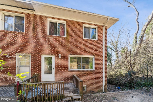 view of front of home featuring brick siding and a deck