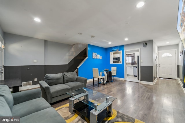 living area featuring baseboards, visible vents, wood finished floors, and recessed lighting