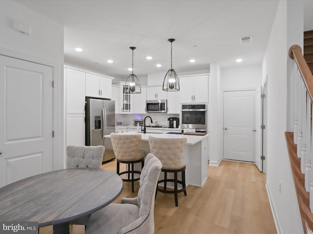 kitchen with light countertops, visible vents, appliances with stainless steel finishes, white cabinets, and a sink