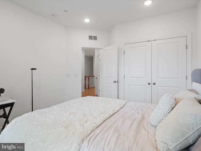 bedroom featuring a closet, wood finished floors, visible vents, and recessed lighting