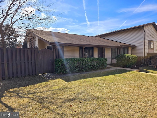 view of front of property with a front yard, fence, and a gate