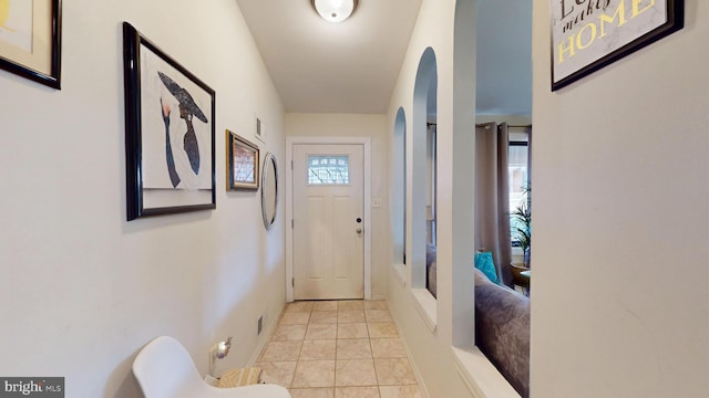 doorway to outside featuring light tile patterned flooring