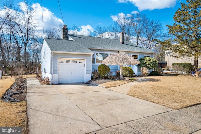 single story home featuring a garage, driveway, a shingled roof, a chimney, and a front lawn