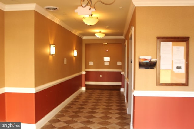 hall featuring ornamental molding, visible vents, baseboards, and tile patterned floors