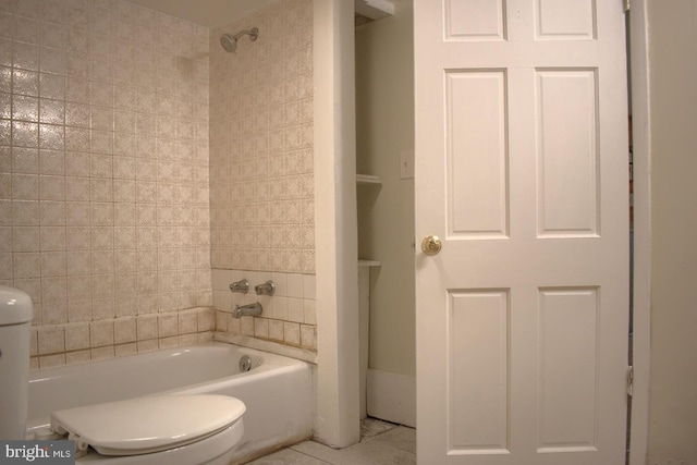 bathroom with tile patterned flooring, tub / shower combination, and toilet