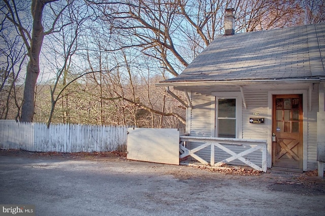 property entrance featuring fence and a chimney