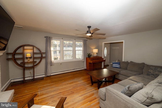 living room with a baseboard heating unit, visible vents, light wood-style flooring, and a ceiling fan