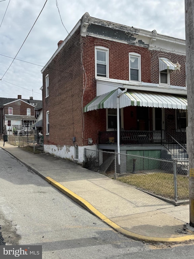 view of front of house featuring a fenced front yard and brick siding