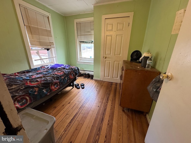 bedroom with hardwood / wood-style flooring and a baseboard radiator