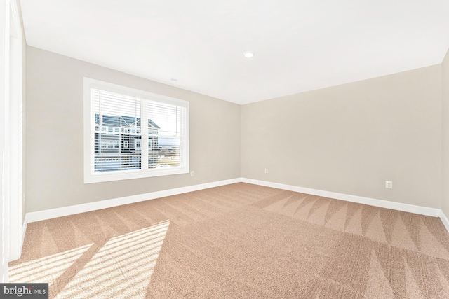 empty room featuring carpet flooring and baseboards