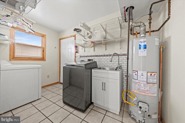 laundry room featuring cabinet space, gas water heater, washing machine and clothes dryer, a sink, and light tile patterned flooring