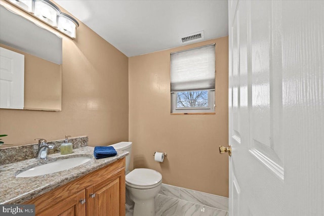 bathroom with toilet, vanity, visible vents, baseboards, and marble finish floor