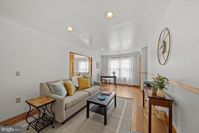 living area with light wood-type flooring, baseboards, and recessed lighting