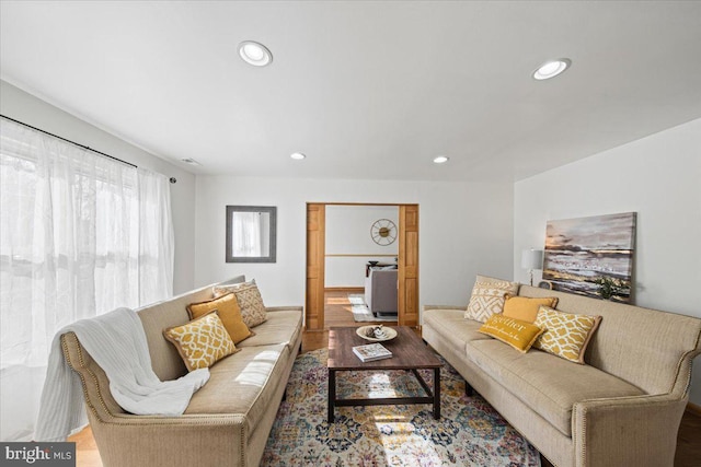 living area with wood finished floors and recessed lighting